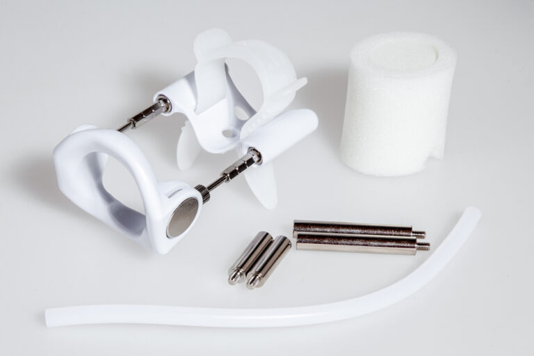 Penisal traction device with silicone tube, foam support, extension rods, and traction components for penile traction therapy.